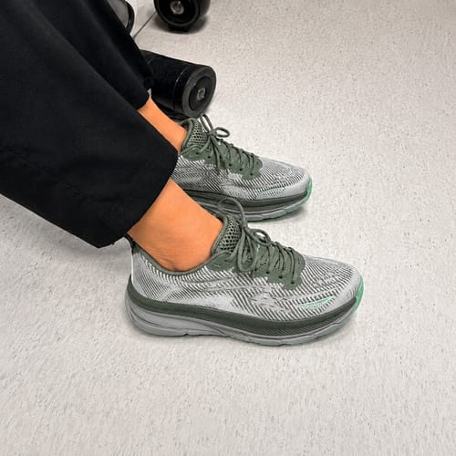 Customer wearing grey and green Ortho Walk™ shoes on a hospital floor.