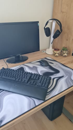 Das RZ Mousepad eines Kunden in Schwarz und Weiß auf einem Schreibtisch mit Tastatur und Maus.