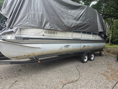 Customer's pontoon boat with dull, stained pontoons before cleaning with Absolute Acid.