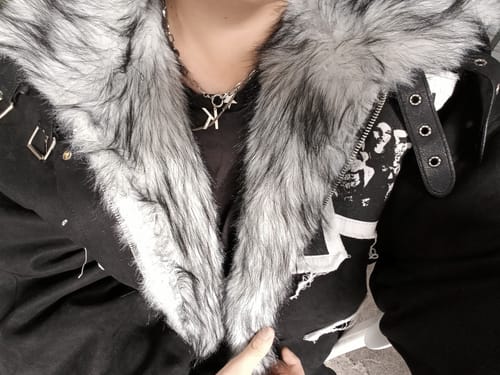 Close-up of a reviewer wearing the Faux Fur Collar Jacket, showing the large grey fur and graphic patch details.