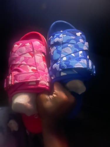 Customer holding a pink camouflage DracoSlide and a blue camouflage DracoSlide.