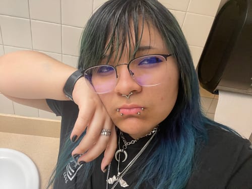 A reviewer wearing the Deathwing Pendant as part of a layered necklace and chain look.