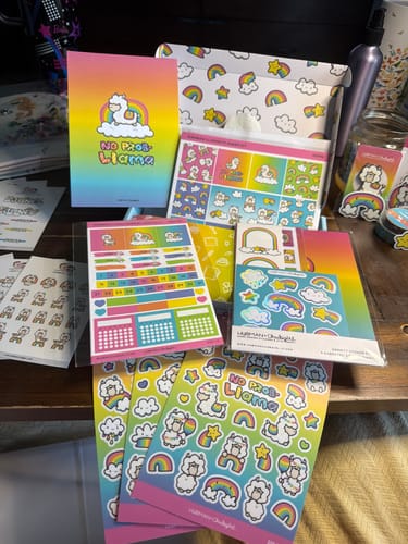 Customer showing the contents of the Ultimate Subscription, including various rainbow and llama-themed sticker sheets.