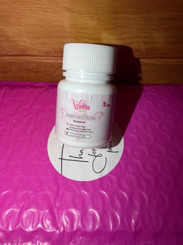 A customer's bottle of Restore Pops displayed on a thank-you note atop a pink bubble mailer.