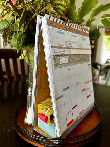 Customer's patterned Pen Pouch tucked inside the base of a standing desk planner.