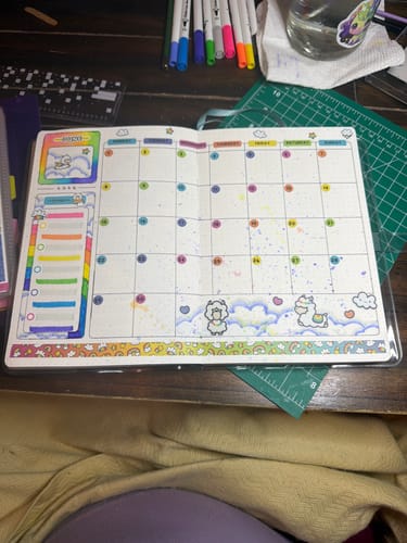 Reviewer's monthly calendar spread decorated with colorful llama and cloud stickers from the subscription.