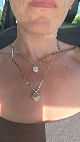 Reviewer wearing the Hanalei Pearl Coin Paperclip Necklace layered with a second gold necklace against their skin.