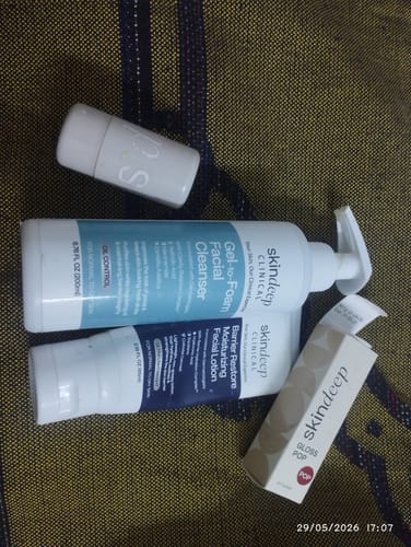 Reviewer's Barrier Restore Moisturizing Facial Lotion tube displayed among other Skindeep products on a textured surface.