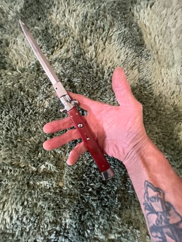 Customer holding the massive 13" Big Boy Stiletto knife open in their hand, showing the red handle and long blade.