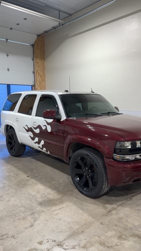 Reviewer's custom-painted SUV parked in a garage, showing the dark Terraflex Carbon Tint on the windows.