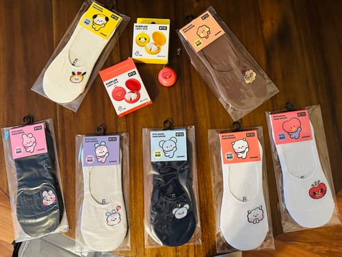 Customer's red Tata and yellow Chimmy BT21 MININI EARPLUGs shown with other BT21 character socks.