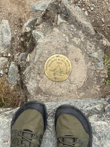 Customer's green Forestep Ⅰ - Barefoot Shoes standing by the historic marker at Machu Picchu.