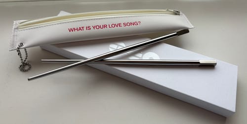 Customer's BTS Arirang stainless steel chopsticks and white carrying pouch on top of the product box.