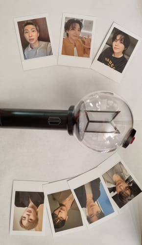 Customer's BTS Official Light Stick Ver.4 displayed on a white surface with several included member photocards.