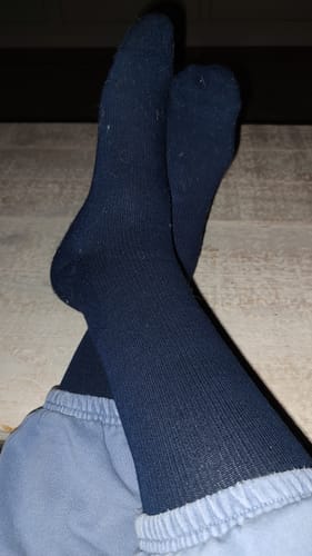 Customer relaxing with their feet crossed, wearing the dark Performance Eucalyptus Compression Socks.