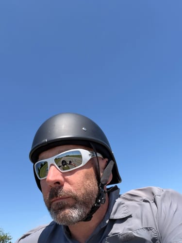 Reviewer wearing the matte black Lightweight Reversible Helmet outdoors under a clear blue sky.