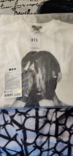 Customer's white BTS Arirang T-shirt in its original packaging, showing the black-and-white graphic of V.