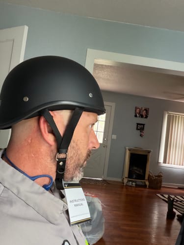 Customer's side profile view of the matte black Lightweight Reversible Helmet, showing its snug fit.