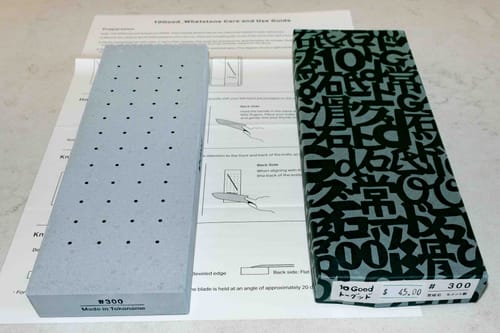 Customer's 10Good #300 Sharpening Whetstone in its inner box, placed next to the outer packaging and user guide.