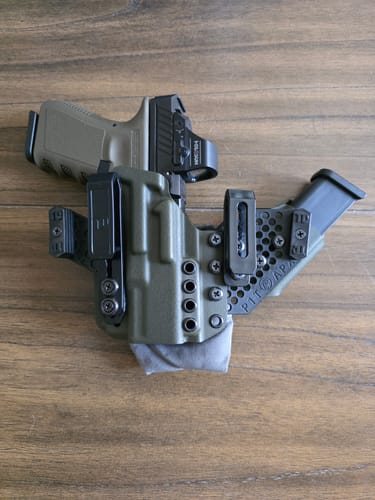 Customer's olive green APX holster configured with a handgun, red dot sight, and an attached magazine carrier.