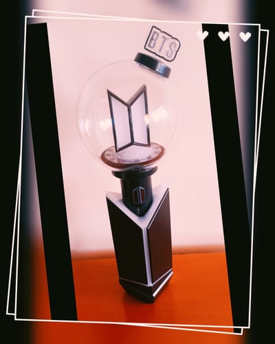 Customer's BTS Official Light Stick Ver.4 standing upright on a wooden table.