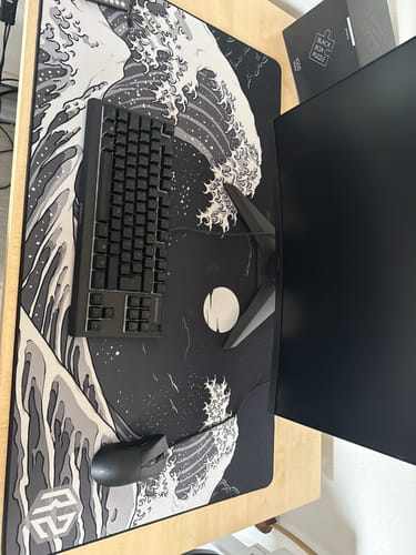 Rezensent zeigt das RZ Mousepad Kangawa Black auf einem Schreibtisch mit einer Tastatur.