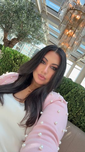 Reviewer takes a selfie wearing the pink Knit Pearl Crop Cardigan over a white top.