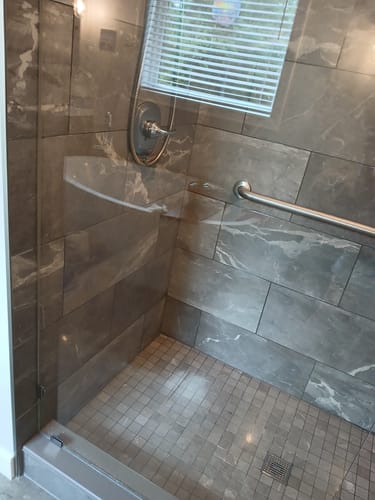 Customer's clean and clear glass shower door in a tiled shower after using Bathroom Concentrate 4x.