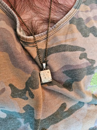 Close-up of a reviewer wearing the square pyrite crystal pendant on a chain necklace.