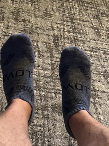 Reviewer wearing a pair of dark, low-cut Men's Alpaca Socks.