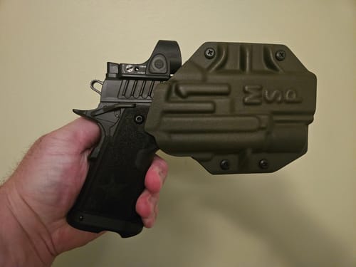 Customer's hand holding a Staccato P pistol fitted into the green MSP OWB holster.
