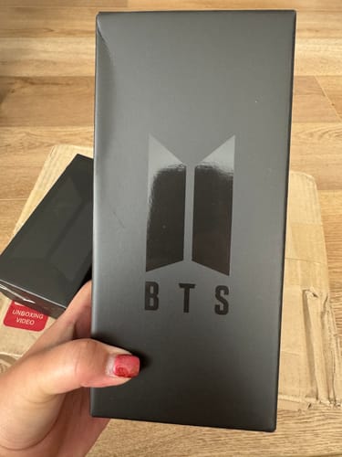 Customer holding the black packaging box for the BTS Official Light Stick Ver.4.