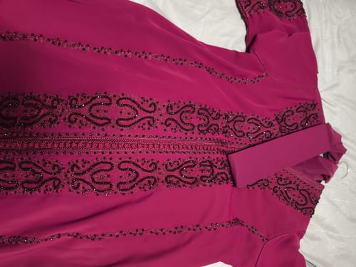 Customer's magenta Kaftan Topaz laid flat, showing the detailed dark embroidery and matching belt.