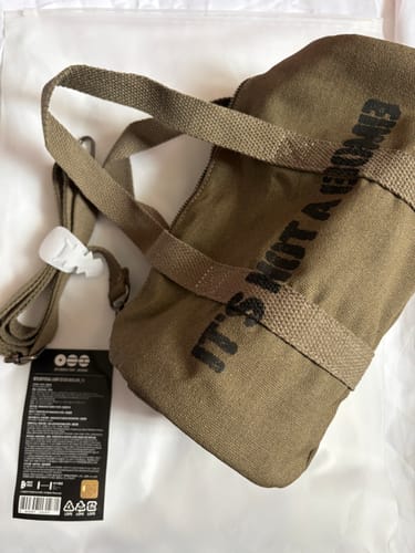 Reviewer's khaki BTS official light stick bag, shown laid out with its straps and tag still attached.