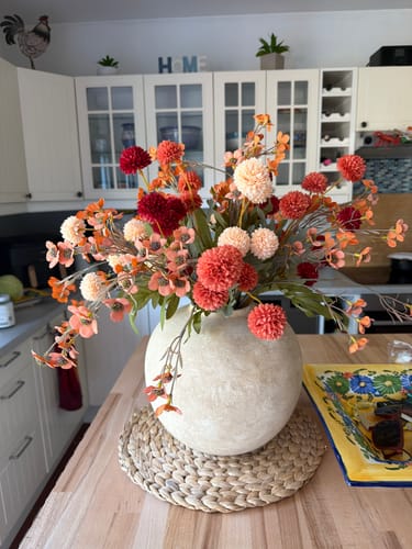 Recensent toont de ronde Terra vaas, gevuld met een kleurrijk boeket in een keuken.