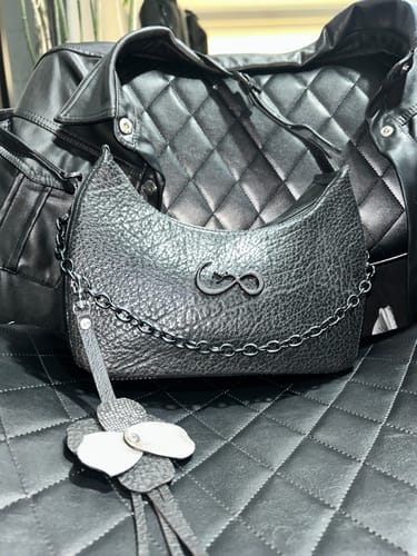 Opinión de un cliente sobre su Bolso "Celine" negro de piel texturizada con cadena, exhibido sobre una superficie acolchada.