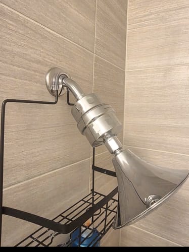 Customer's chrome Shower Head Filter installed on a shower arm in a tiled shower.