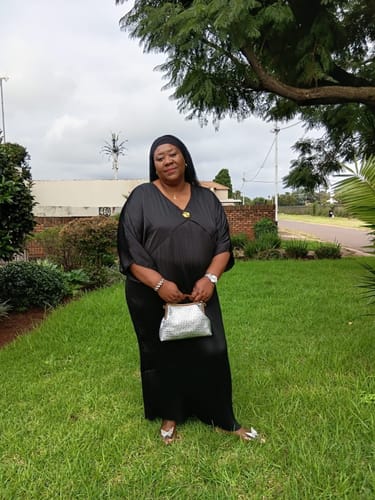 Customer dressed for a gala, holding the elegant silver handbag mentioned in her review.