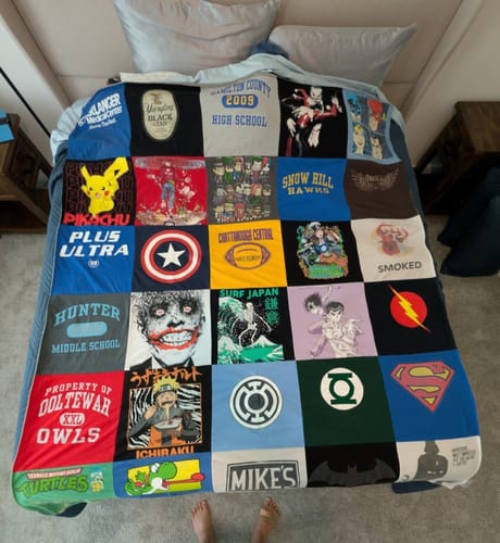 Customer's large Premium T-Shirt Quilt with many pop culture and school graphics laid out on a bed.