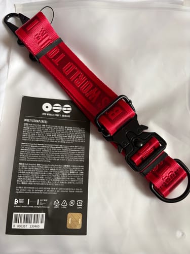 Reviewer's red BTS Multi Strap with black hardware, shown with its product tag.