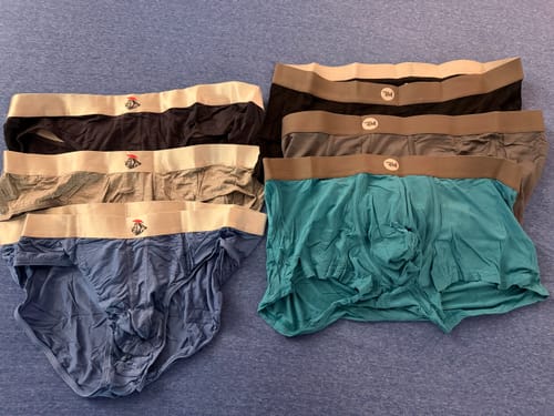 Customer's collection of Modal Briefs and boxer briefs in various gray, blue, and black colors laid out.