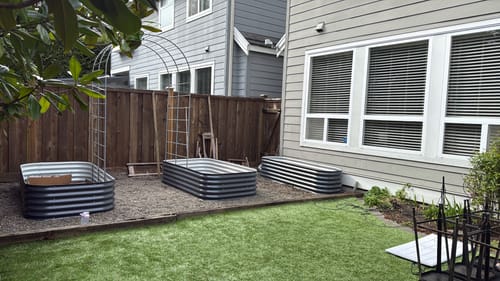 Customer's Arch Garden Trellis during assembly between two Sproutbox garden beds in a backyard.