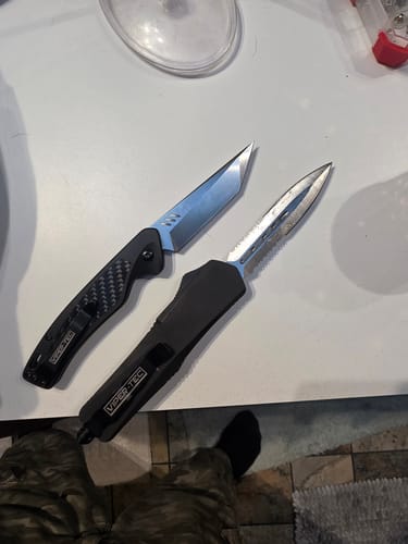 Customer shows two knives from their EDC Mystery Bundle: a black OTF knife and a folding knife with a tanto blade.