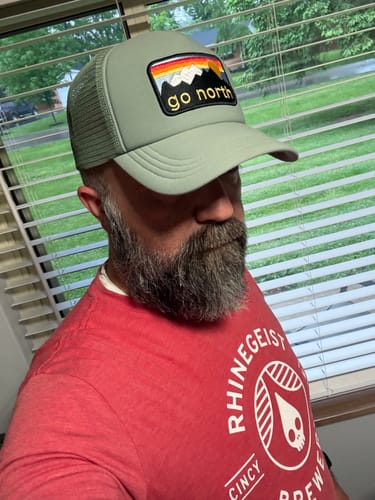 Reviewer wearing the light green Big Foam Trucker Hat, showing its color and fit.