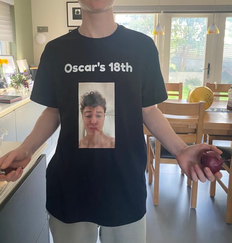 Customer wearing a custom black unisex t-shirt with 'Oscar's 18th' and a photo printed on the front.