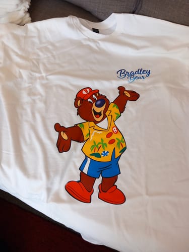 Customer's white unisex t-shirt laid flat, showing the 'Bradley Bear' cartoon graphic.