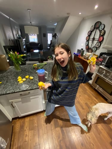 Reviewer in a kitchen, excitedly making the blueberry lemonade mentioned in their review.