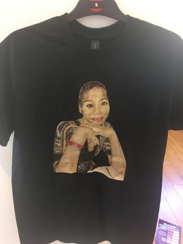 Customer's black unisex t-shirt on a hanger, featuring a custom photo design.