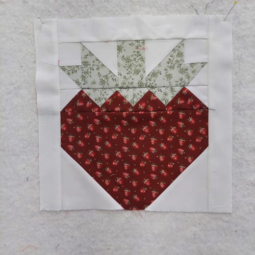 Customer's pieced strawberry block from the Strawberry Fields quilt kit, showing the red and green fabrics.
