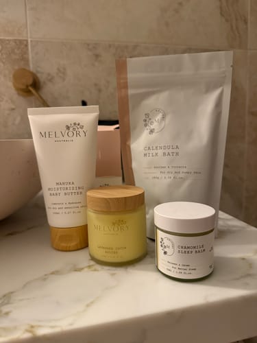 Customer's Skin Rescue Set products, including Lavender Cocoa Butter and Calendula Milk Bath, on a bathroom counter.